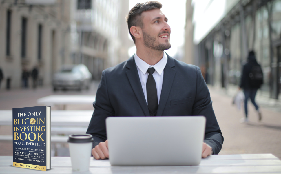 Man with laptop and Bitcoin book